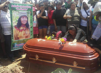 People cry over the coffin of plant healer Olivia Arevalo during her burial in Ucayali, Peru.