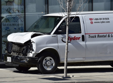 A van with a damaged front-end is shown on a sidewalk after a van mounted a sidewalk crashing into a number of pedestrians.
