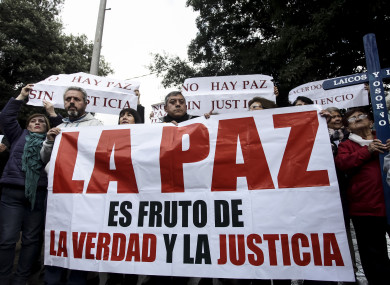 File photos of lay members of the Catholic Church carrying a sign that reads in Spanish “Truth and justice bear peace”.