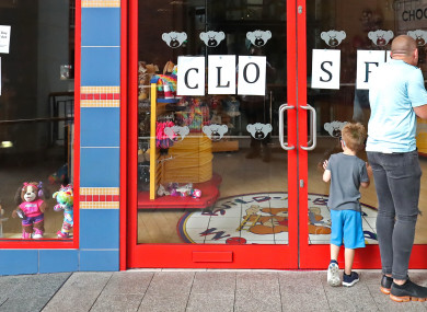 Passersby at the closed shop in Belfast