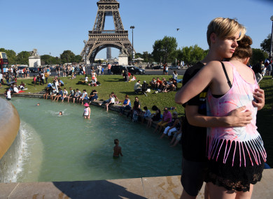 People cool down at the Fontaine du Trocadero in front of The Eiffel Tower in Paris, France