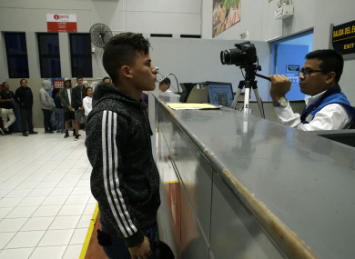 A Venezuelan migrant stand for a photo at a migration checkpoint before the deadline on new regulations that demand passports from migrants in Tumbes, Peru,