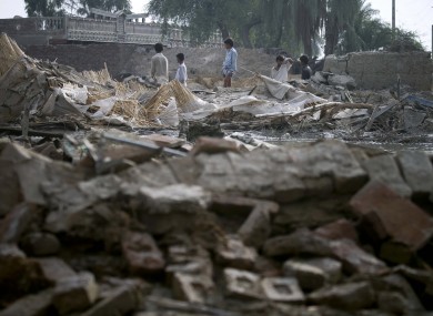 Pakistani youngsters survey the collapsed houses by heavy floodwaters in Lundi village near Karampur, in southern Pakistan.