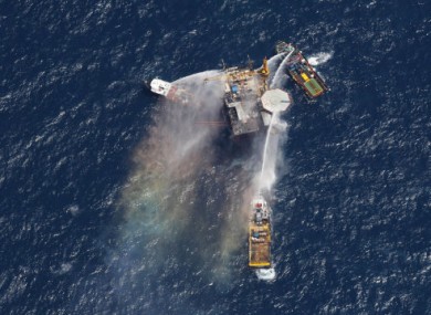 Boats are seen spraying water on an oil and gas platform that exploded in the Gulf of Mexico, off the coast of Louisiana., Thursday, Sept. 2, 2010.