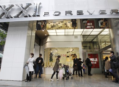 Shoppers stand in front of the main entrance of Forever 21 in Tokyo.