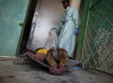 The body of a man that doctors say died of cholera lies on a stretcher at a morgue in Saint Marc, Haiti.
