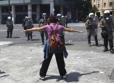 A woman demonstrator faces police during a demo in Athens