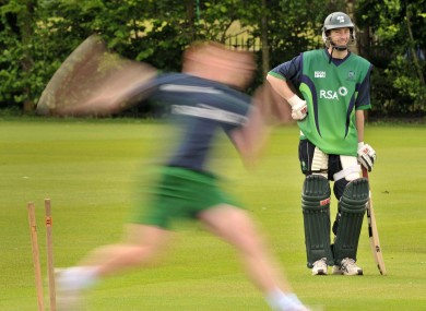 Alex Cusack watches Kevin O'Brien bowling.