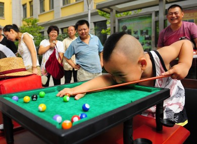 A boy plays pool during a competition exclusively for left-handed people, in Xi'an, Shaanxi Province, China.