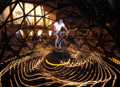 Lighting artist Bruce Munro rides the bike powering his Star Turn installation at a museum in Bath