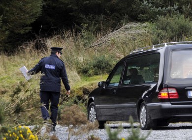 A garda directs a hearse at the scene of the body's discovery yesterday.