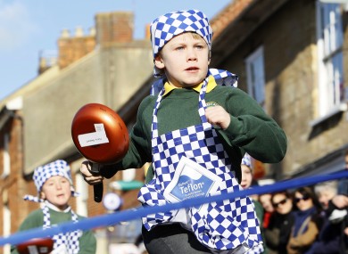 Harry Bennett, 6, from Olney Infant Academy in England races to the finish line of today's pancake race.