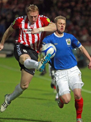 Derry's Stewart Greacen sees off the challenge of Linfield's Peter Thompson at the Brandywell last night.