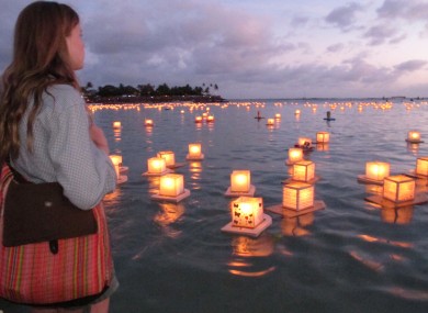 Julia Douglas, 18, of Honolulu, watches lanterns float by at an annual ceremony in Hawaii to commemorate loved ones.