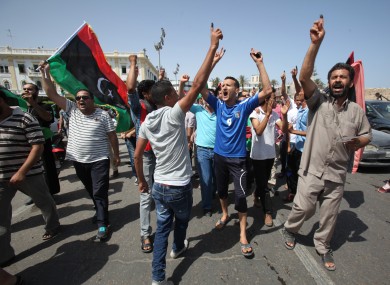 Libyans hold up their ink marked fingers after voting in last month's elections