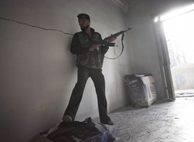 Free Syrian Army soldier takes cover while fighting against Syrian Army troops in Aleppo, Syria, Tuesday, Oct. 2, 2012