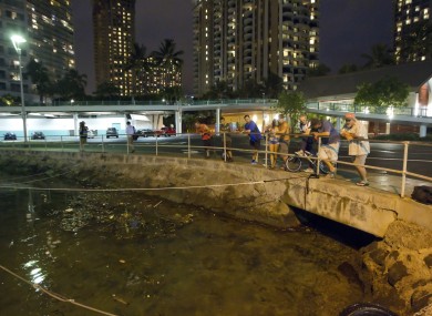Visitors and Oahu residents watch the water level in the Ala Wai Harbour, while waiting for the arrival of a tsunami a few hours ago. The state's tsunami warning has now been lifted.
