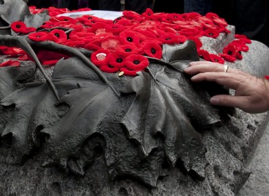 A man pauses as he touches the Tomb of the Unknown Soldier after placing his poppy on top following Remembrance Day ceremonies at the National War Memorial in Ottawa.