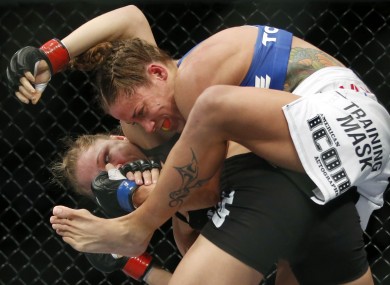 Liz Carmouche, top, grapples with Ronda Rousey during their UFC 157 women's bantamweight championship mixed martial arts match.