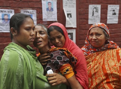 Bangladeshi relatives of missing workers in a building that collapsed on Wednesday comfort each other in Savar.