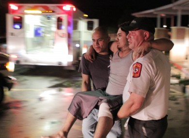 Johnny Ortiz, left, and James South, right, carry Miguel Morales, center, who was injured in a tornado, to an ambulance in Granbury, Texas, on Wednesday May 15, 2013.