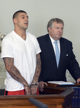 Former New England Patriots tight end Aaron Hernandez, left, stands with his attorney Michael Fee.