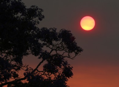 The sun glows a deep orange colour as the light is filtered through smoke haze from wildfires drifts over Sydney.