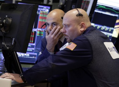 A pair of traders work in their booth on the floor of the New York Stock Exchange earlier