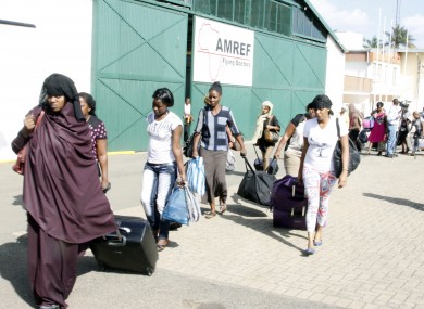 Kenyans carry their bags after being evacuated from South Sudan by the Kenyan Defence Forces at Wilson Airport in Nairobi, Kenya.