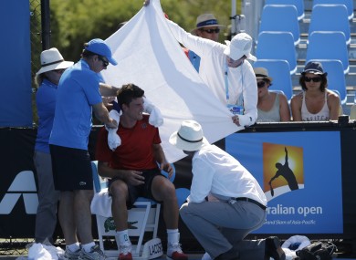 Frank Dancevic of Canada is protected from the sun after collapsing.