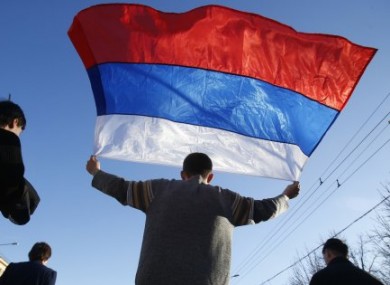 An activist carries a Russian flag during a rally at a central square in Donetsk, eastern Ukraine