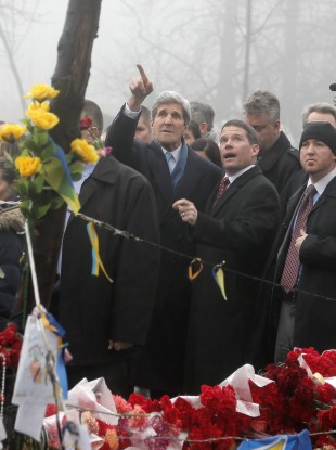 US Secretary of State John Kerry points to the bullet hole in a tree during a visit to Kiev