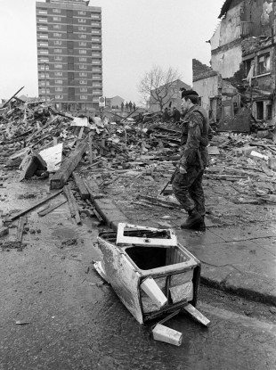A soldier stands guard over the shattered remains of McGurk's bar in North Queen Street, Belfast.