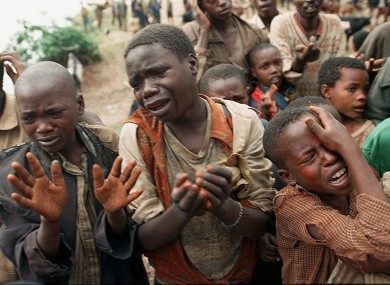 Rwandan refugee children plead with Zairean soldiers to allow them across a bridge separating Rwanda and Zaire where their mothers had crossed moments earlier before the soldiers closed the border on 20 August 1994.