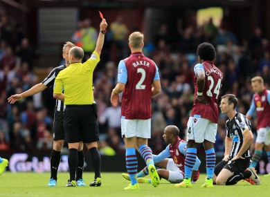 Newcastle United's Mike Williamson (right) is shown a red card by referee Mike Dean for a foul on Aston Villa's Fabian Delph.
