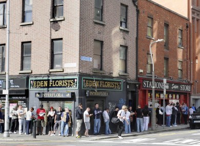 File photo of people waiting outside a social welfare office.