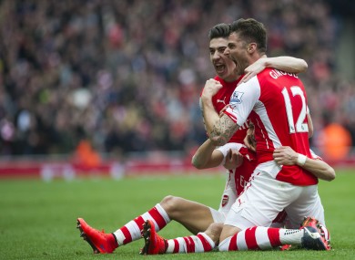Arsenal's Alexis Sanchez, partially seen at bottom, celebrates with teammates Olivier Giroud, right, and Hector Bellerin.