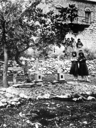 Women standing In the graveyard of Distomo, Greece, where victims of a 1944 Nazi massacre are buried