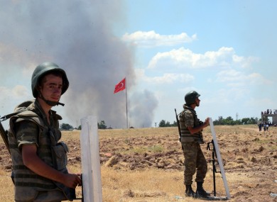 Turkish soldiers stand guard on the Turkish side of the border in Suruc. Kurdish fighters have besieged Islamic State members who entered Kobani.