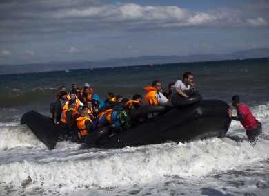 File photo of a rubber boat carrying migrants and refugees arrives at a beach on the northern coast of Lesbos.