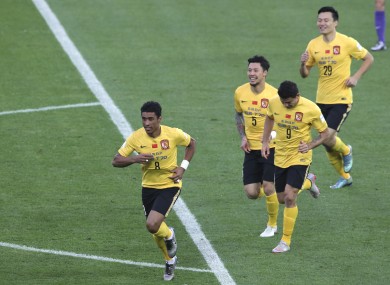 Guangzhou Evergrande's Paulinho of Brazil (8) celebrates with teammates after scoring a goal.