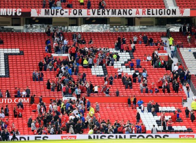 Manchester United fans leave the stand after a security announcement yesterday.