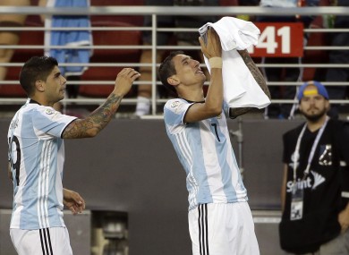 Argentina's Angel Di Maria, right, holds a t-shirt that reads