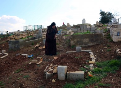 Syrian refugee Saada Khalaf, 45, who fled from the city of Homs, Syria, cries near the grave of her husband Ali Jomaa, in the eastern village of Dalhamyeh, in the Bekaa valley, Lebanon.