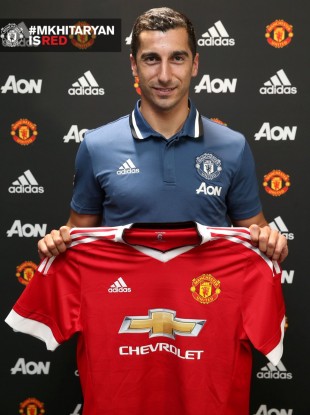 Mkhitaryan holds up the United shirt.