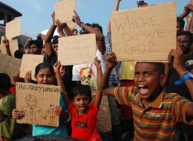 File image: Sri Lankan asylum seekers who were caught in Indonesian waters while trying to sail to Australia hold up posters during a demonstration.