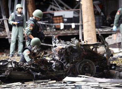 Thai bomb squad officers examine the wreckage of a car after an explosion outside a hotel in Pattani province, southern Thailand.