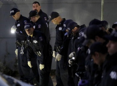 New York City Police officers search for clues on a street where a shooting took place in the Bronx borough of New York.
