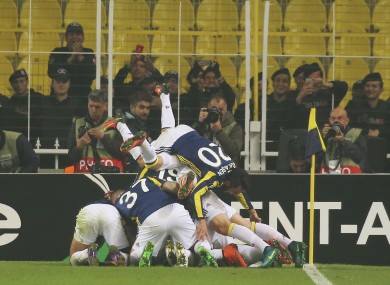 Fenerbahce players celebrate with their teammate Jeremain Lens, obscured, after he scored against Manchester United