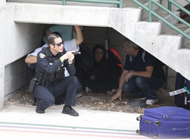 Law enforcement personnel shield civilians outside a garage area at Fort Lauderdale.